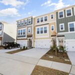 A row of colorful modern townhouses in a suburban neighborhood on a sunny day.