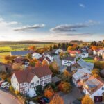 Charming aerial view of a rural village in autumn with vivid colors and clear skies.