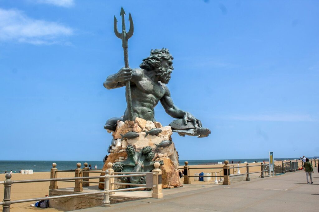 a statue of a man holding a fish on a beach. Virginia Beach Pressure Washing
